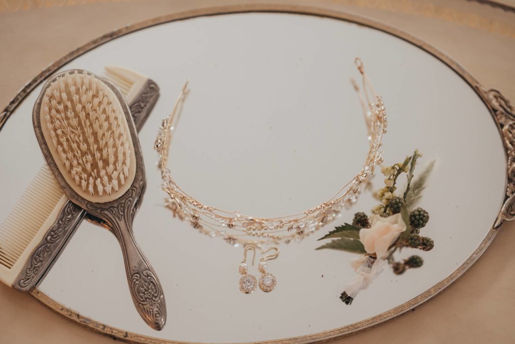 Hair piece, boutonnière and earrings displayed on mirror