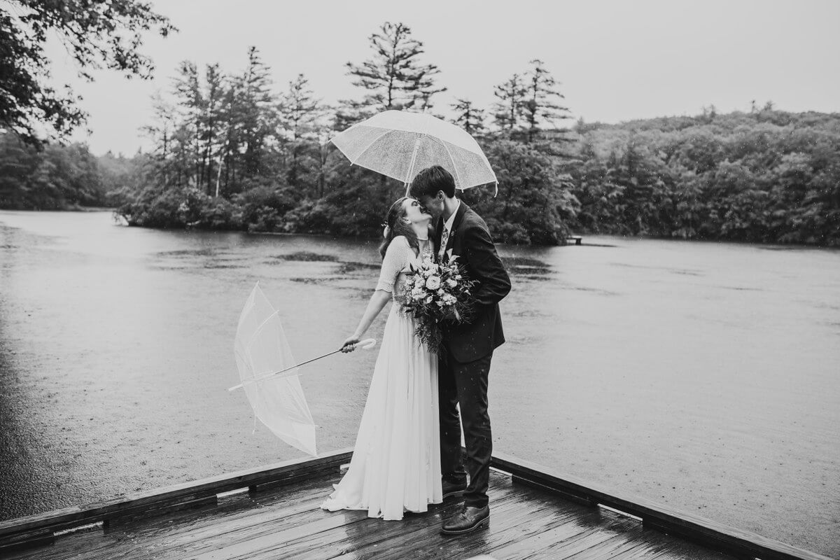 Couple kissing in the rain on their wedding day